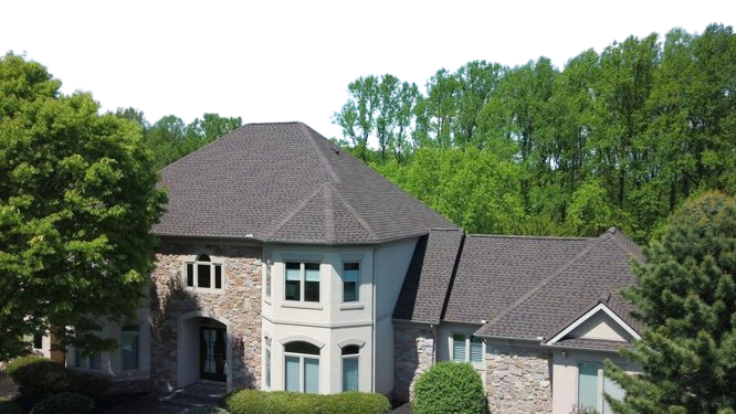 A large home with a spacious driveway surrounded by trees, showcasing a 3D roof animation design in New Jersey.