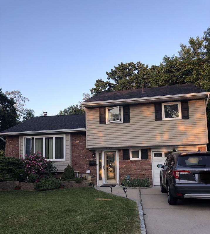 A house with a car parked in front, featuring a 3D animated roof design in New Jersey.